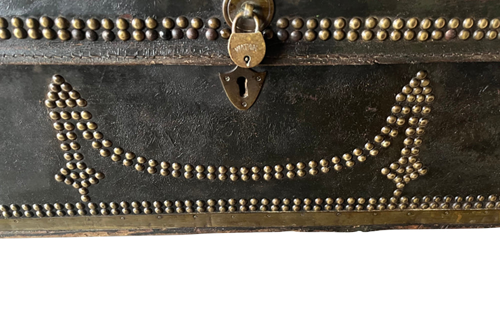 An early 19th century brass banded and studded leather trunk