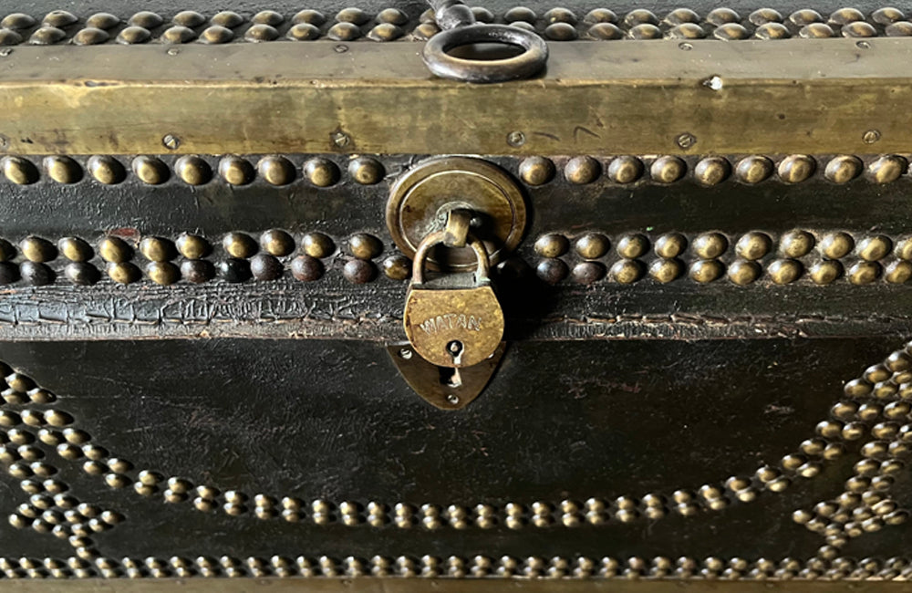 An early 19th century brass banded and studded leather trunk