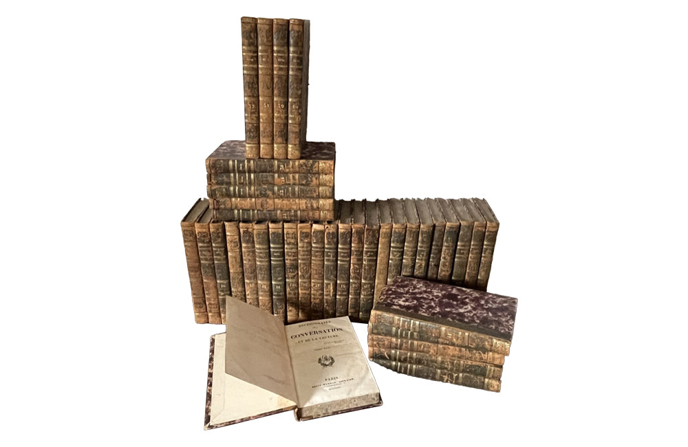 Early 19th century collection of thirty eight worn leather spined books with purple marbled paper covered boards.