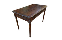 19th century walnut desk decorated with carved with Neo-Classical motifs to all sides.