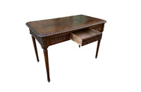 19th century walnut desk decorated with carved with Neo-Classical motifs to all sides.