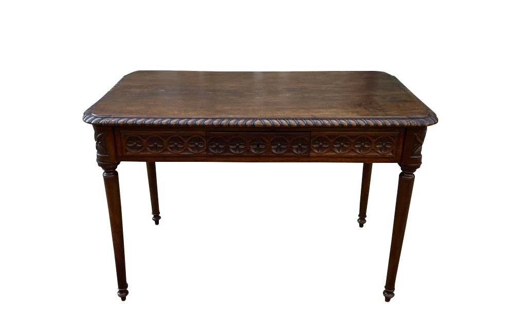 19th century walnut desk decorated with carved with Neo-Classical motifs to all sides.