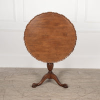 Carved Chippendale style tilt top table with large pie crust top resting on a turned pedestal with urn and carved legs terminating in claw and ball feet.