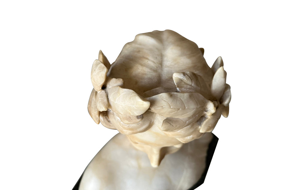 20th Century marble bust of a serene young woman with laurel wreath in hair and fine robe.