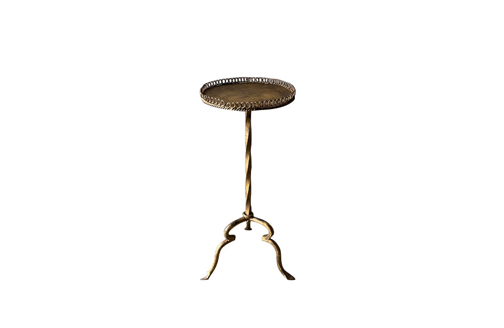Spanish, gilt iron martini table with decorative coiled rim top, twisted stem and shaped tripod base with arrow point feet.