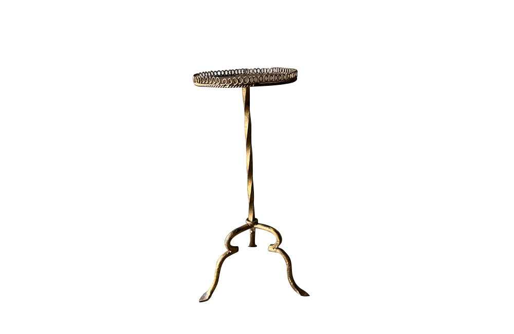 Spanish, gilt iron martini table with decorative coiled rim top, twisted stem and shaped tripod base with arrow point feet.