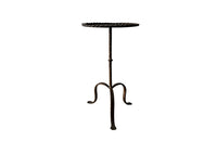 Spanish, gilt iron cocktail table with hammered and rope rim top on hammered ringed stem and decoratively shaped tripod base.
