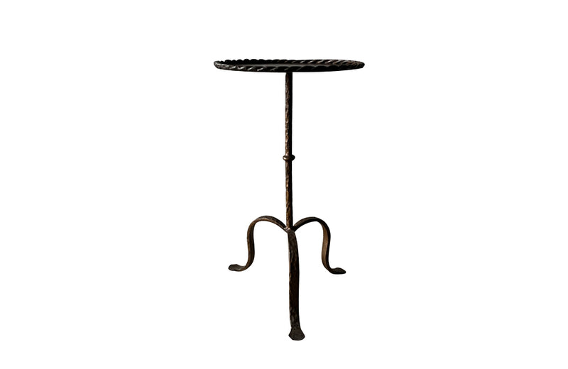 Spanish, gilt iron cocktail table with hammered and rope rim top on hammered ringed stem and decoratively shaped tripod base.