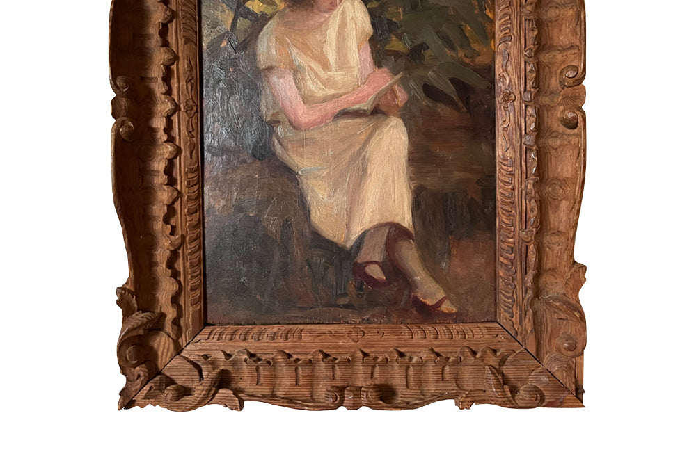 Charming framed oil on wood painting of a seated young woman reading in her garden .