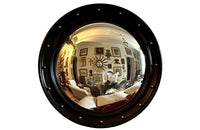 Stylish, round ebonised sorciere mirror decorated with brass balls to the surround.