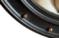 Stylish, round ebonised sorciere mirror decorated with brass balls to the surround.