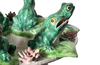 20th century glazed terracotta centrepiece in the form of a basket with seven open mouthed frogs on flowering water lily pads surrounding the rim.