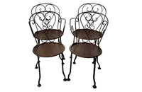 set of four French antique wrought iron garden chairs, comprising two armchairs and two chairs. Each has lovely scrolled ironwork and pierced iron seats. Circa 1900