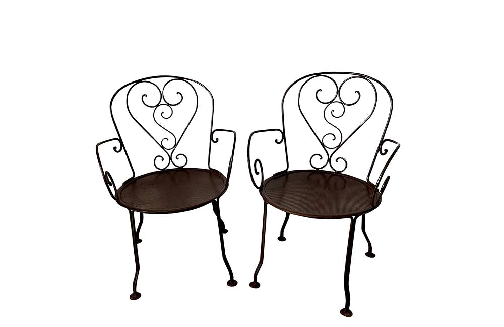 set of four French antique wrought iron garden chairs, comprising two armchairs and two chairs. Each has lovely scrolled ironwork and pierced iron seats. Circa 1900