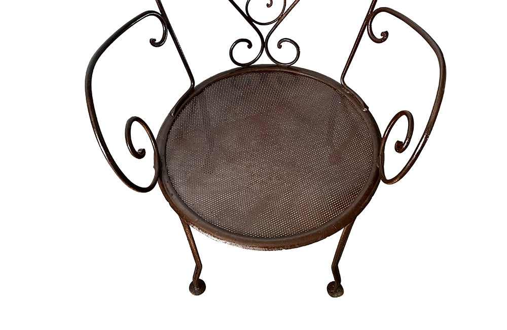 set of four French antique wrought iron garden chairs, comprising two armchairs and two chairs. Each has lovely scrolled ironwork and pierced iron seats. Circa 1900