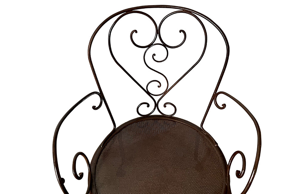 set of four French antique wrought iron garden chairs, comprising two armchairs and two chairs. Each has lovely scrolled ironwork and pierced iron seats. Circa 1900