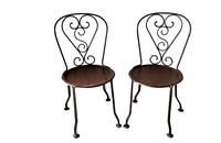 set of four French antique wrought iron garden chairs, comprising two armchairs and two chairs. Each has lovely scrolled ironwork and pierced iron seats. Circa 1900