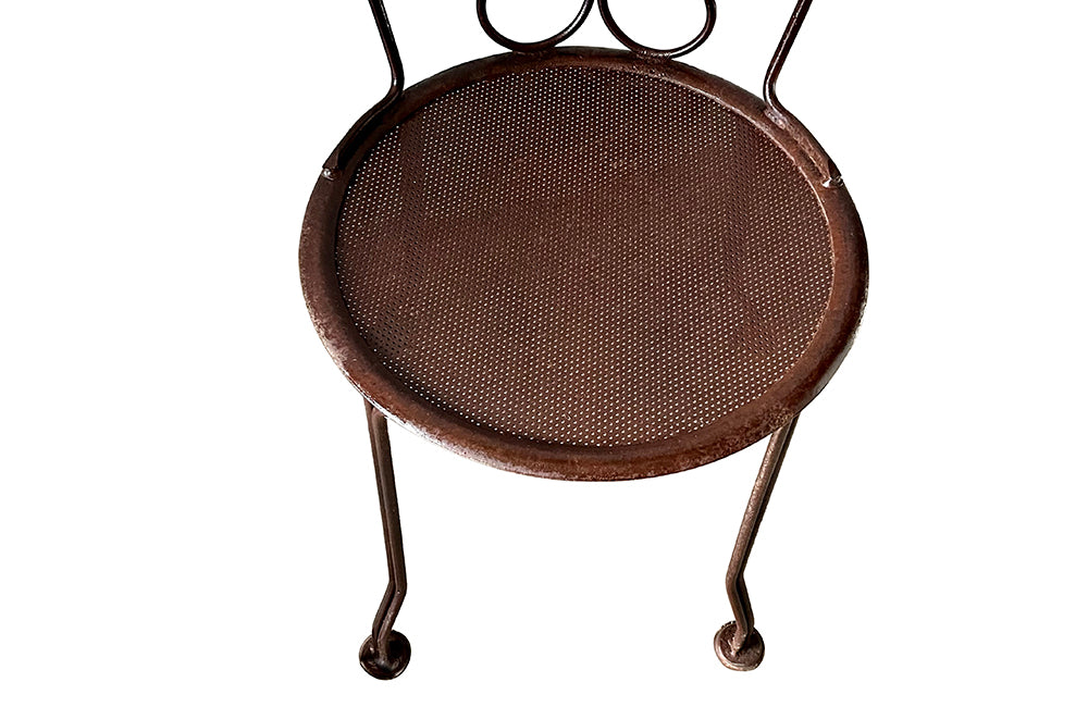 set of four French antique wrought iron garden chairs, comprising two armchairs and two chairs. Each has lovely scrolled ironwork and pierced iron seats. Circa 1900