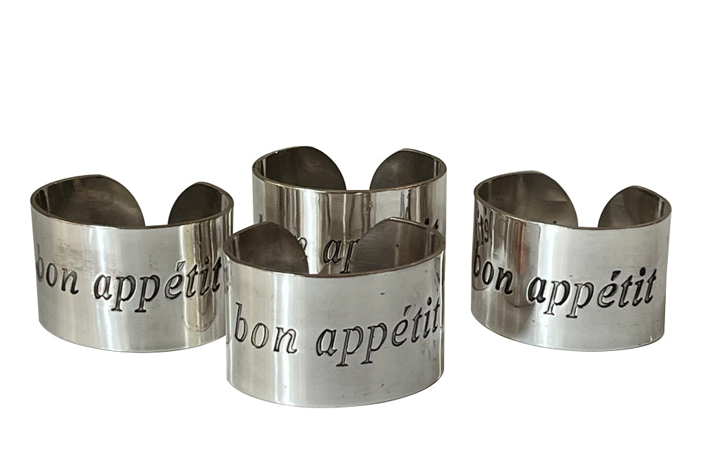Set of four decorative napkin holders with Bon Appétit inscribed to each.