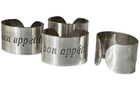 Set of four decorative napkin holders with Bon Appétit inscribed to each.