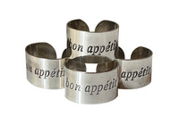 Set of four decorative napkin holders with Bon Appétit inscribed to each.