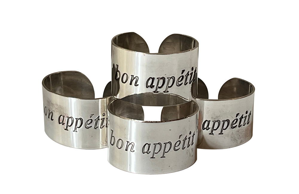Set of four decorative napkin holders with Bon Appétit inscribed to each.