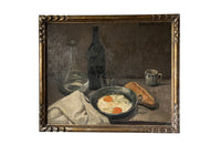 Lovely, French still life painting of fried eggs in a pan, a carafe of water, bottle of wine, glass, loaf of bread, ceramic cup and cloth napkin.