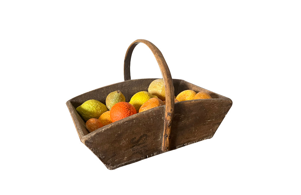 Antique wooden harvest panier filled with marble trompe l'oeil lemons, limes, oranges and mandarins.Italian
