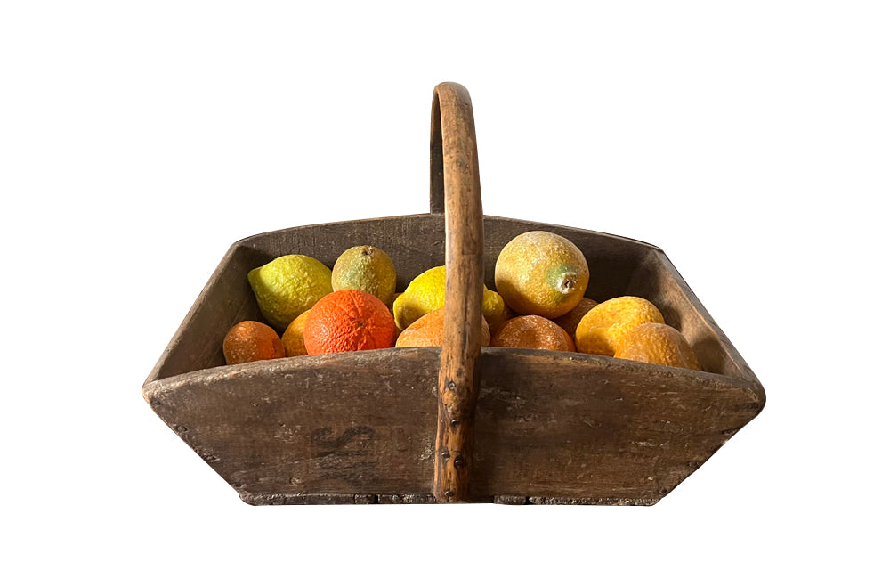 Antique wooden harvest panier filled with marble trompe l'oeil lemons, limes, oranges and mandarins.Italian