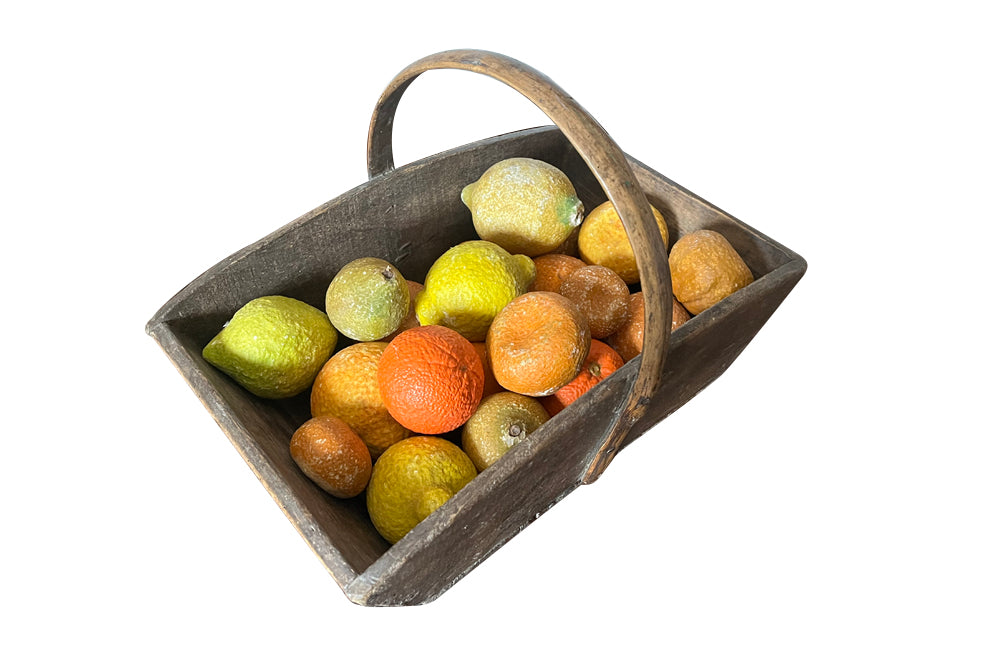 Antique wooden harvest panier filled with marble trompe l'oeil lemons, limes, oranges and mandarins.Italian