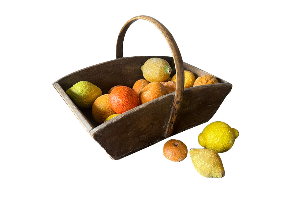 Antique wooden harvest panier filled with marble trompe l'oeil lemons, limes, oranges and mandarins.Italian