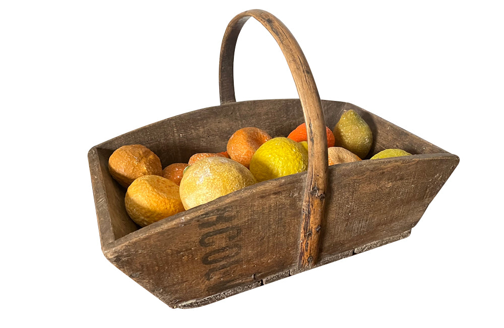 Antique wooden harvest panier filled with marble trompe l'oeil lemons, limes, oranges and mandarins.Italian