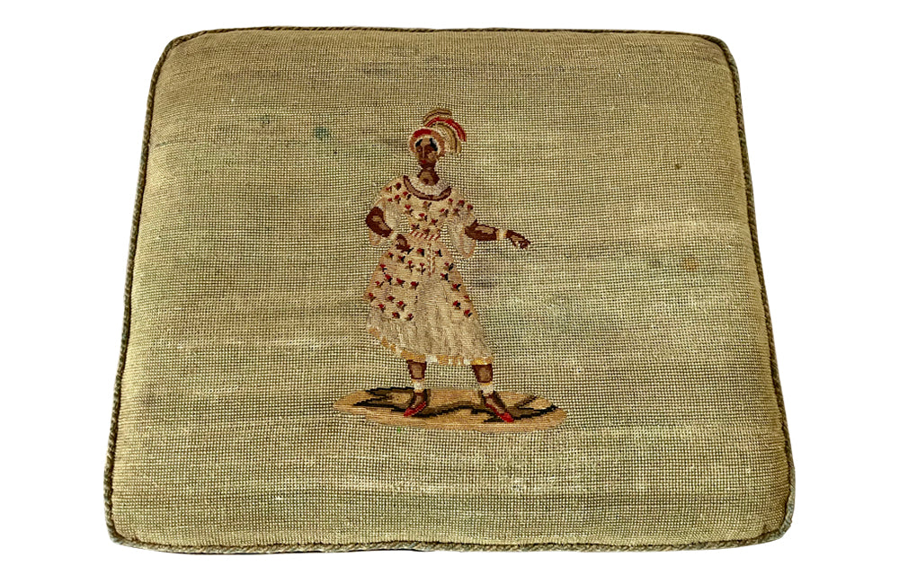 Oak x frame stool in the Neo-Classical style with spindle stretcher its charming tapestry depicting a Caribbean female figure. 19th century