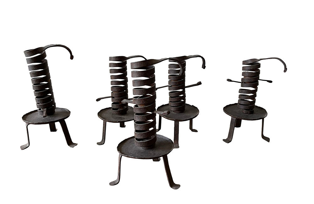 COLLECTION OF FIVE FRENCH IRON CELLAR CANDLESTICKS