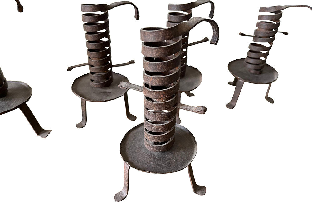 COLLECTION OF FIVE FRENCH IRON CELLAR CANDLESTICKS