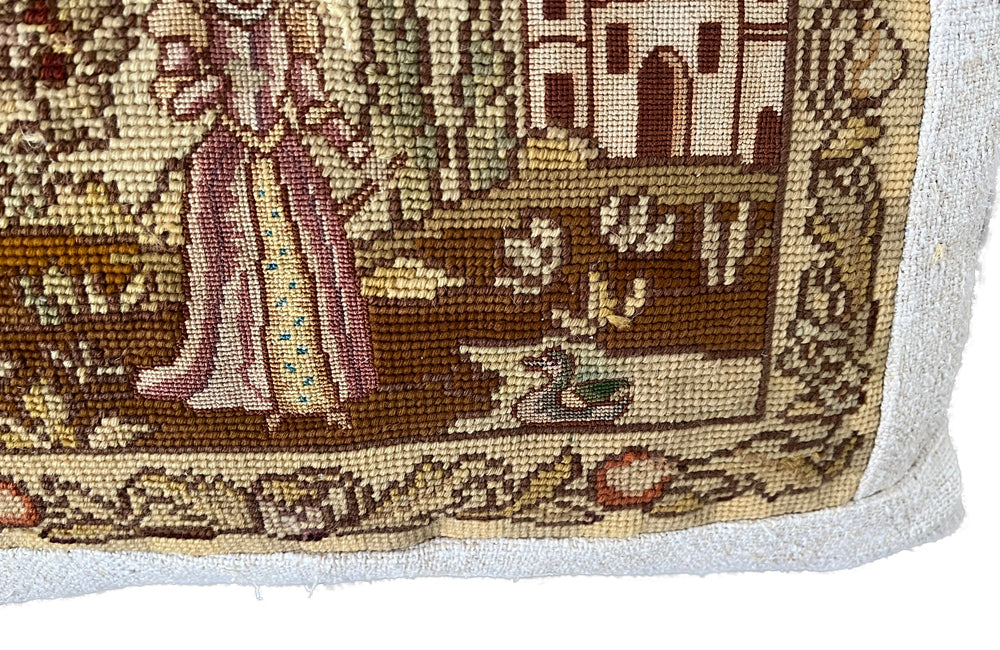 Charming cushion made with a 19th Century tapestry depicting a lady in the garden of a chateau with a duck.  It is feather filled and backed with lovely antique hemp fabric