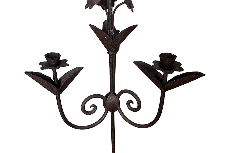 Pair of large wrought iron candle holders from a chateau in the Dordorgne. Tall decorative candlesticks with floral and foliate decoration and have 4 candle holders.