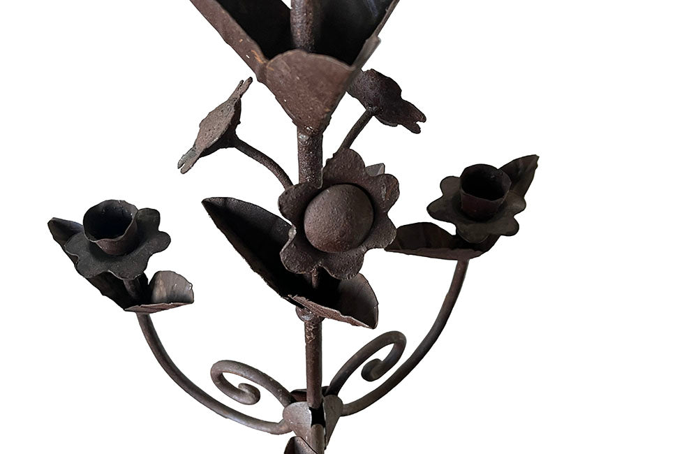 Pair of large wrought iron candle holders from a chateau in the Dordorgne. Tall decorative candlesticks with floral and foliate decoration and have 4 candle holders.