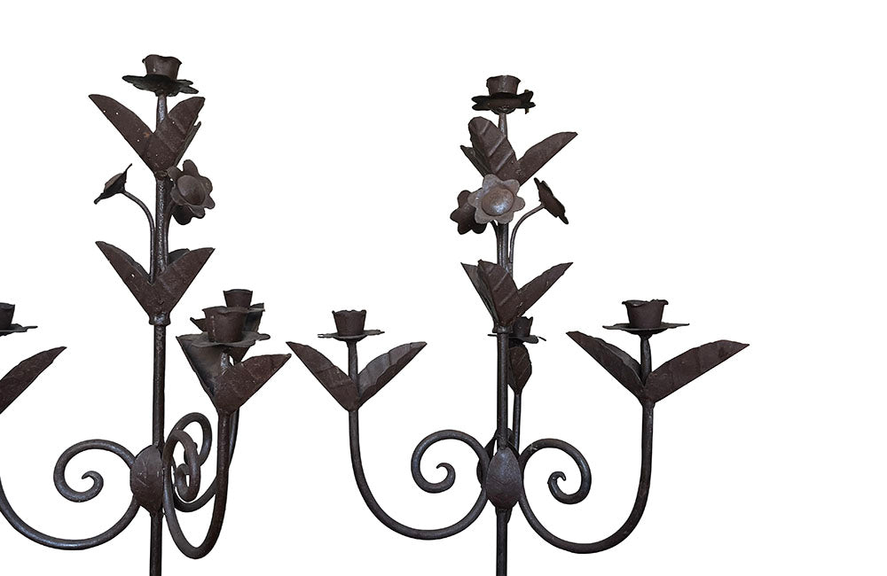 Pair of large wrought iron candle holders from a chateau in the Dordorgne. Tall decorative candlesticks with floral and foliate decoration and have 4 candle holders.