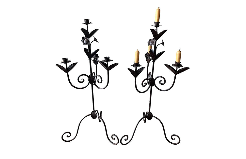 Pair of large wrought iron candle holders from a chateau in the Dordorgne. Tall decorative candlesticks with floral and foliate decoration and have 4 candle holders.