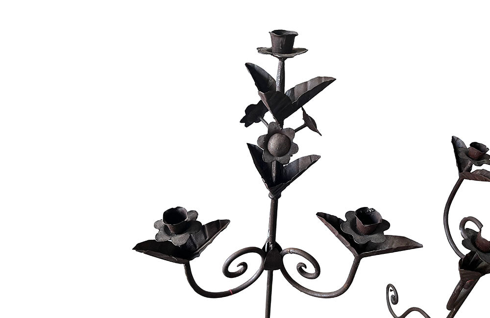 Pair of large wrought iron candle holders from a chateau in the Dordorgne. Tall decorative candlesticks with floral and foliate decoration and have 4 candle holders.