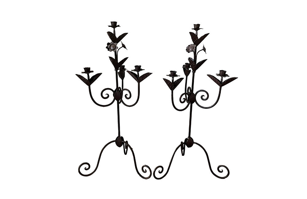 Pair of large wrought iron candle holders from a chateau in the Dordorgne. Tall decorative candlesticks with floral and foliate decoration and have 4 candle holders.