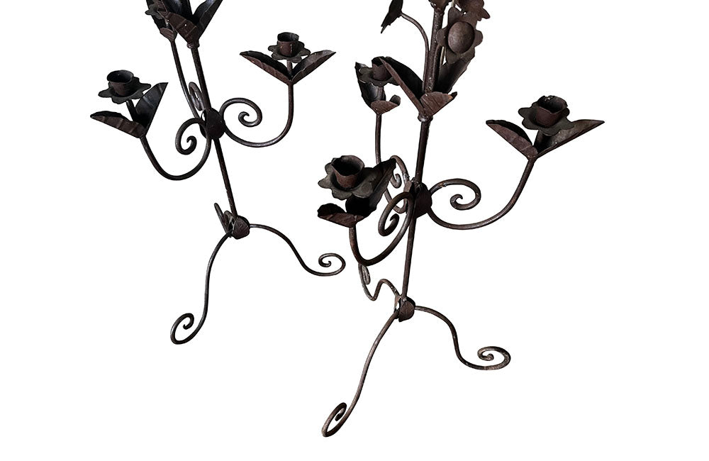 Pair of large wrought iron candle holders from a chateau in the Dordorgne. Tall decorative candlesticks with floral and foliate decoration and have 4 candle holders.