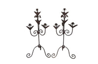 Pair of large wrought iron candle holders from a chateau in the Dordorgne. Tall decorative candlesticks with floral and foliate decoration and have 4 candle holders.