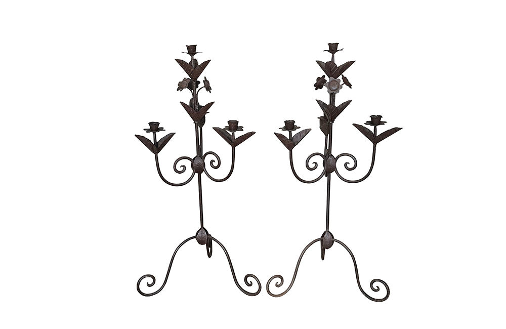 Pair of large wrought iron candle holders from a chateau in the Dordorgne. Tall decorative candlesticks with floral and foliate decoration and have 4 candle holders.