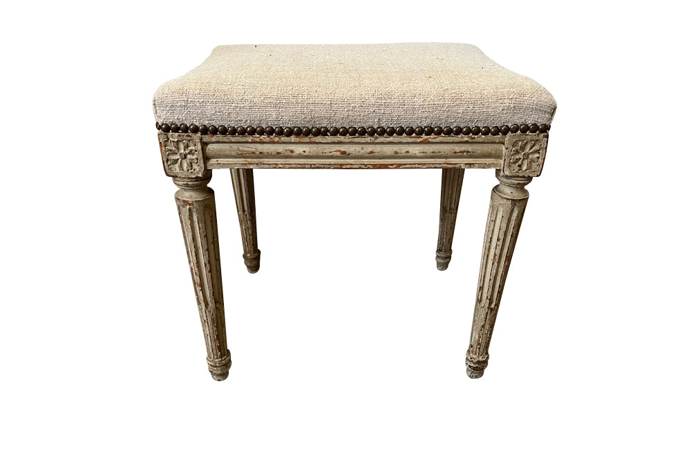 18th century charming painted Louis XVI stool has reeded legs and carving to all sides in the Neo-Classical style.