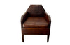 Antique club chair leather with embossed back featuring a putti and scrolled foliate decoration. France.