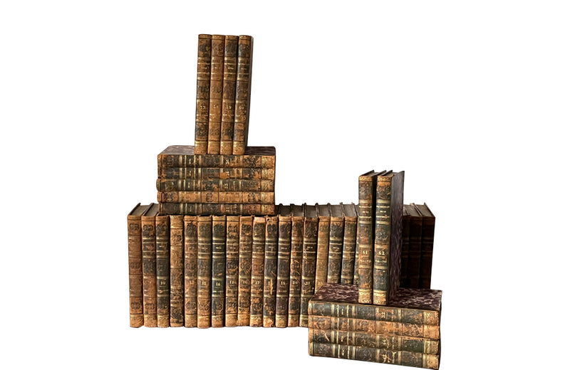 Early 19th century collection of thirty eight worn leather spined books with purple marbled paper covered boards.