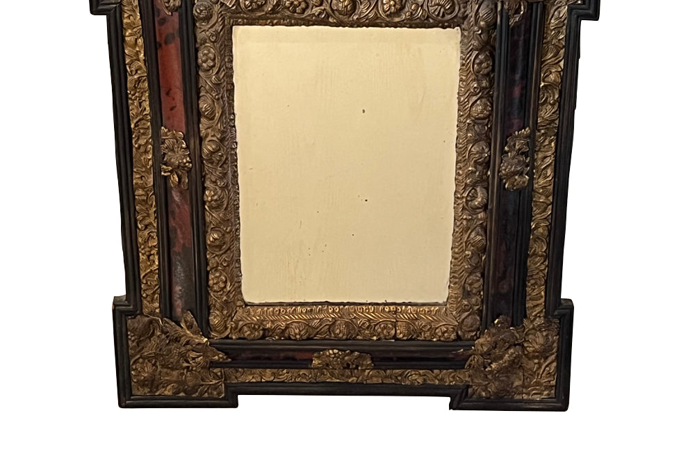 Antique mirror Louis XIV style French with faux tortoiseshell veneer and repousee brass decoration. Richly decorated with floral, foliate and fruit motif.