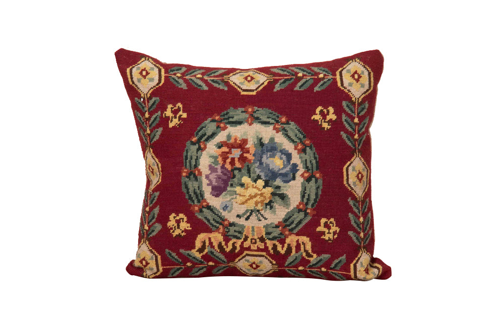 19th Century French needlepoint pillow featuring a classic floral wreath medallion on a deep burgundy ground.